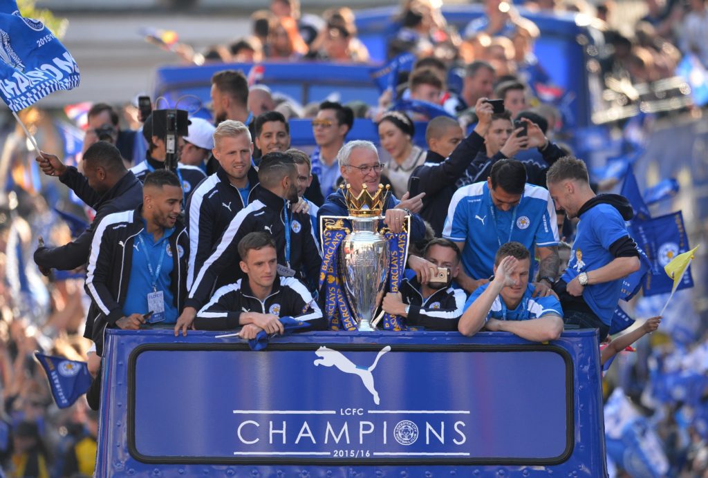 Leicester City's Italian manager Claudio Ranieri (C) stands with the Premier league trophy as the Leicester City team take part in an open-top bus parade through Leicester to celebrate winning the Premier League title on May 16, 2016. / AFP PHOTO / GLYN KIRK