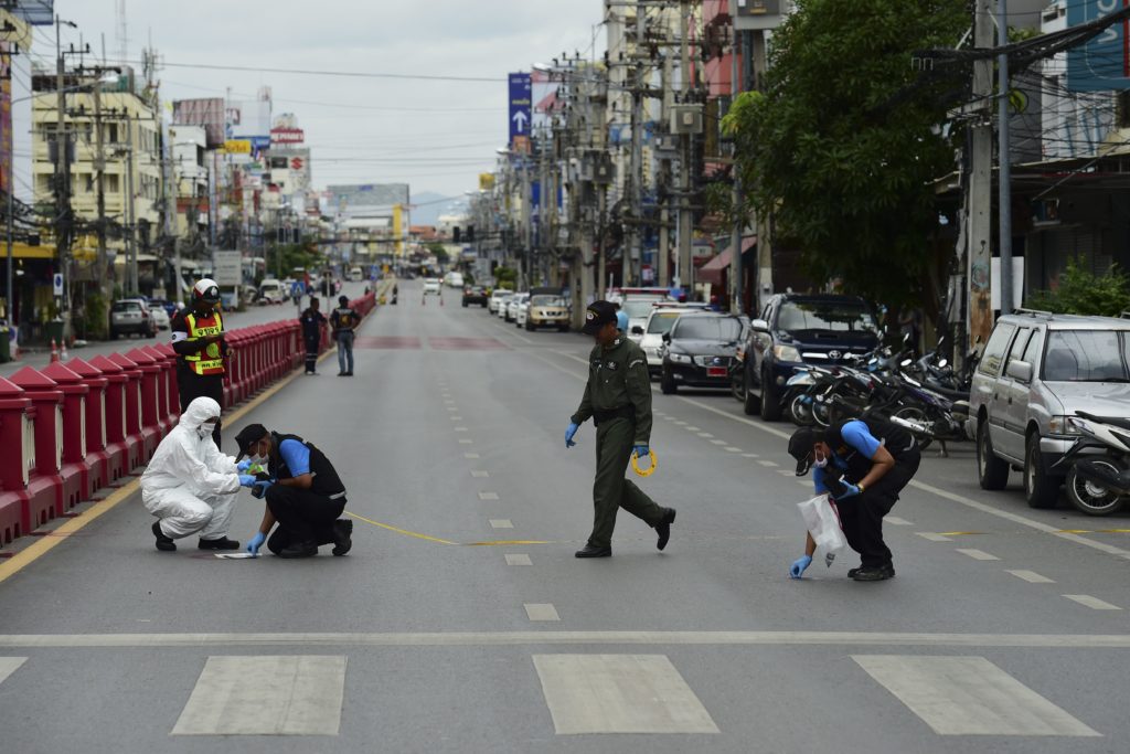 Investigation officials collect evidence from the crime scene after a small bomb exploded in Hua Hin on August 12, 2016. A string of bomb attacks targeting Thailand's crucial tourism industry have killed four people, officials said on August 12, sending authorities scrambling to identify a motive and find the perpetrators. / AFP PHOTO / APF / MUNIR UZ ZAMAN