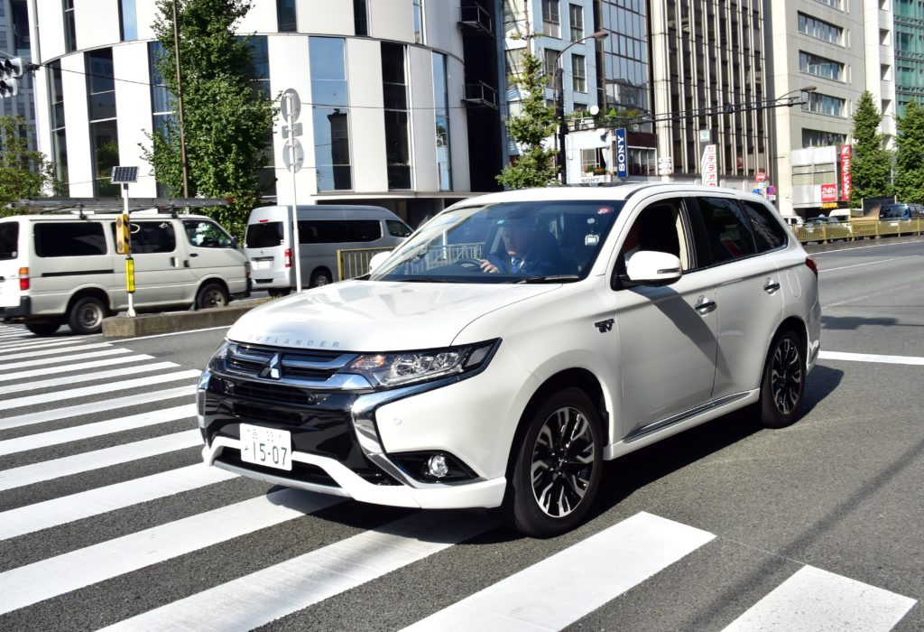 London Mayor Boris Johnson drives the Mitsubishi Motors (MMC) plug-in hybrid vehicle "Outlander PHEV" near the MMC headquarters in Tokyo on October 15, 2015.  AFP PHOTO / Yoshikazu TSUNO / AFP PHOTO / YOSHIKAZU TSUNO