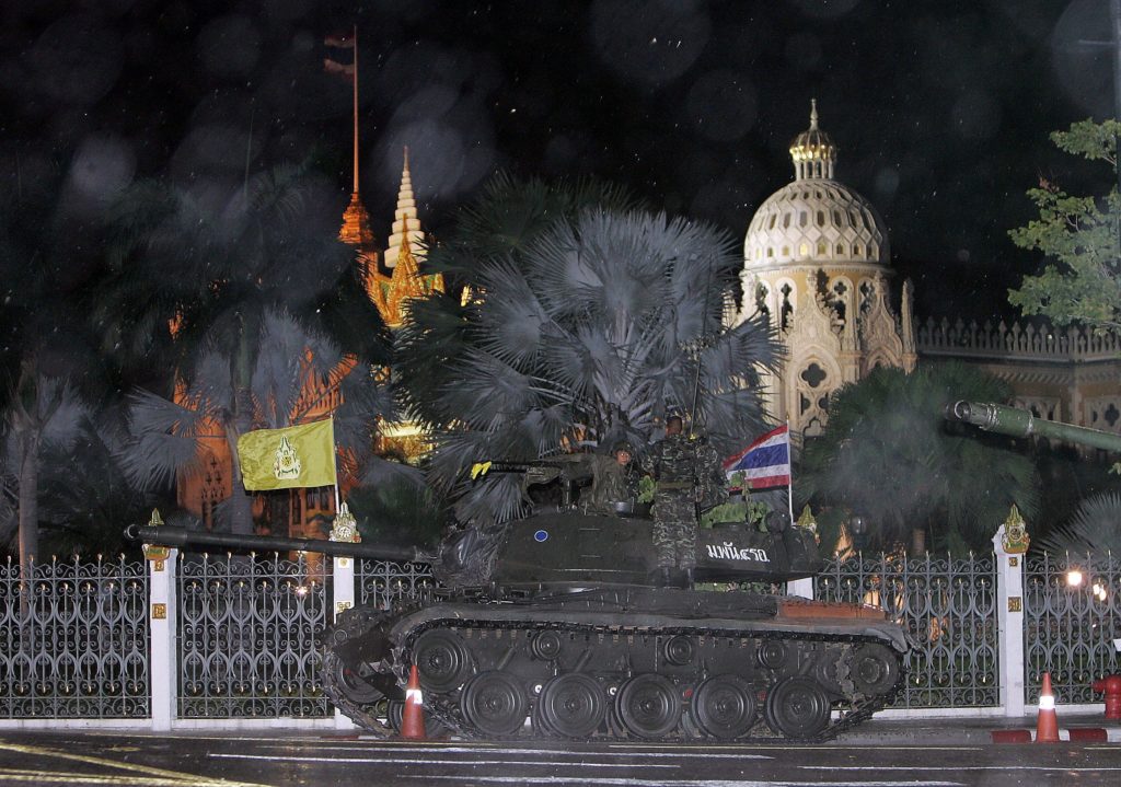 Thai soldiers stand guard on military tanks in front of the Government House in Bangkok, late 19 September 2006. Heavily-armed troops backed by tanks took control of the Thai premier's office in Bangkok while Prime Minister Thaksin Shinawatra was out of the kingdom, witnesses said. Witnesses outside government house in central Bangkok said forces loyal to sacked military commander Lieutenant General Sonthi Boonyaratglin had taken took control of the building in what appeared to be a coup. AFP PHOTO/PORNCHAI KITTIWONGSAKUL / AFP PHOTO / PORNCHAI KITTIWONGSAKUL