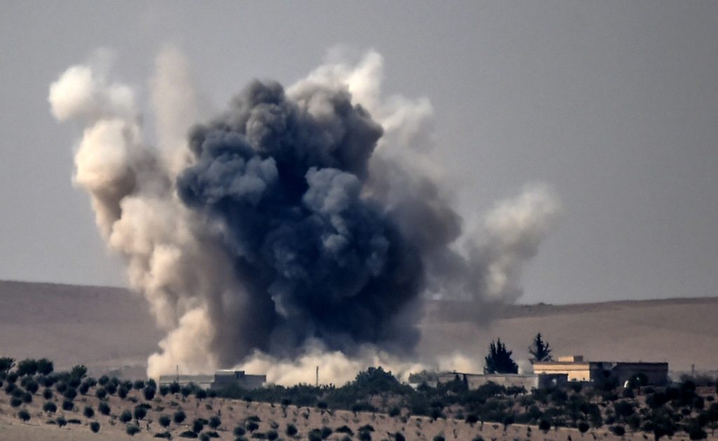 This picture taken from the Turkish Syrian border city of Karkamis in the southern region of Gaziantep, on August 24, 2016 shows smoke billows following air strikes by a Turkish Army jet fighter on the Syrian Turkish border village of Jarabulus during fighting against IS targets. Turkey's army backed by international coalition air strikes launched an operation involving fighter jets and elite ground troops to drive Islamic State jihadists out of a key Syrian border town. / AFP PHOTO / BULENT KILIC
