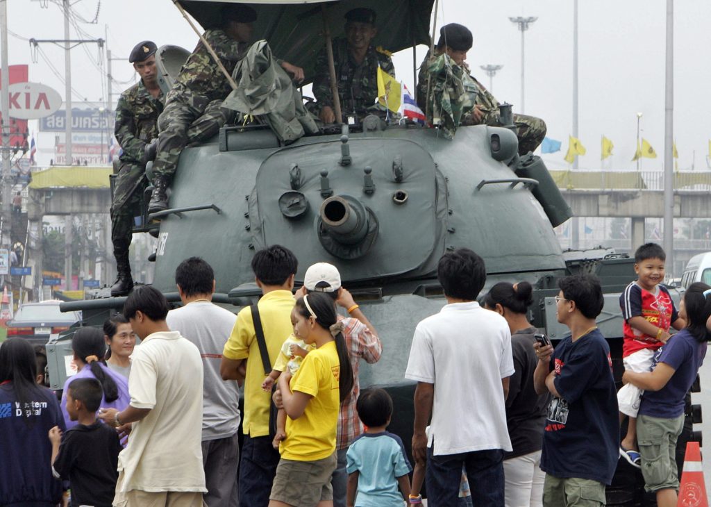 Thai families gather round to take photos with a military tank stationed along a highway suburb of Bangkok, 24 September 2006. Thailand's new military leaders were readying to install a new prime minister this week and step up a corruption probe against the premier they deposed in last week's coup. AFP PHOTO/PORNCHAI KITTIWONGSAKUL / AFP PHOTO / PORNCHAI KITTIWONGSAKUL