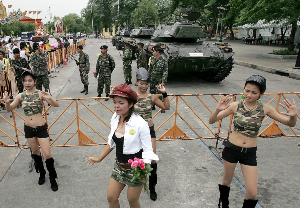 Dancers perform in front of military tanks at the Royal Plazza in Bangkok, 25 September 2006. Nine tanks rolled back into Bangkok's Royal Plaza on 25 September, one day after they had pulled out, as the military said it was redeploying forces around the city after last week's coup. AFP PHOTO/PORNCHAI KITTIWONGSAKUL / AFP PHOTO / PORNCHAI KITTIWONGSAKUL