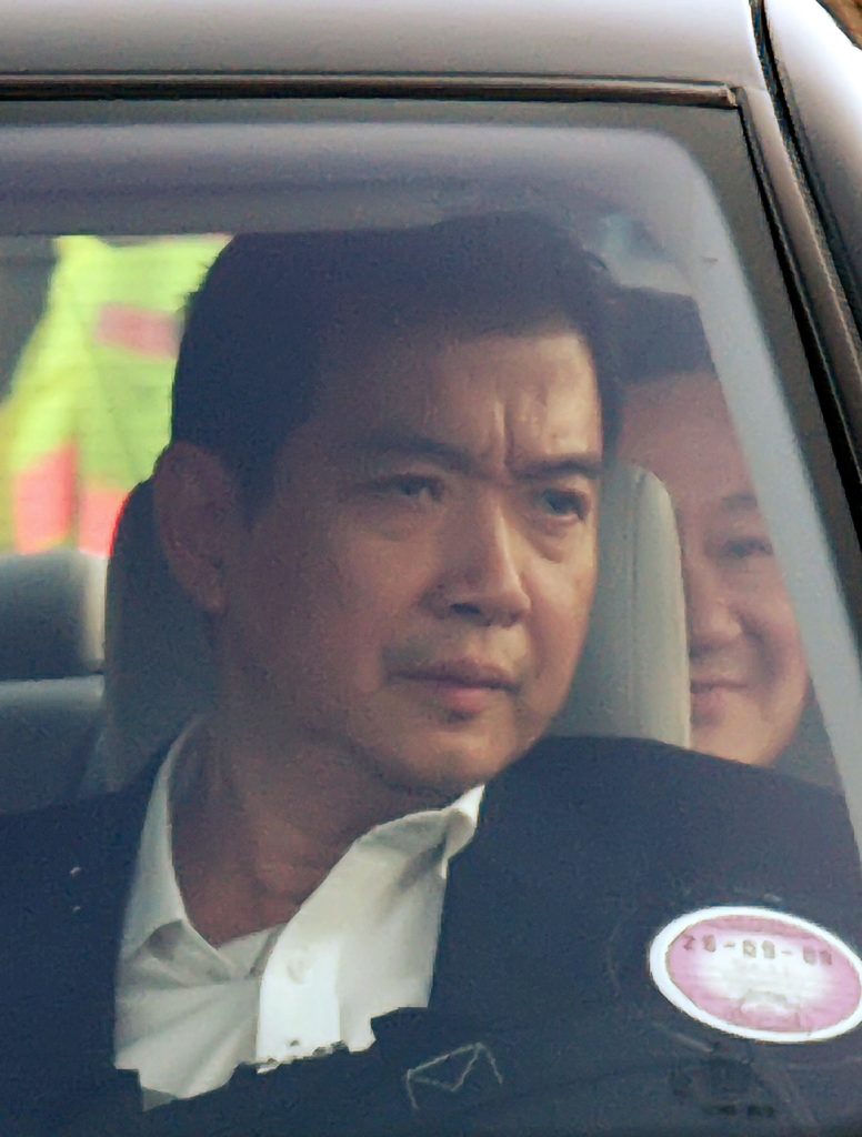 Ousted Thai Prime Minister Thaksin Shinawatra (back R) peers past a body guard from the back seat of a limousine taking him to London from Gatwich airport, 20 September 2006. Shinawatra arrived in London Wednesday for a "private" visit after the military coup in his homeland, amid deep uncertainty about the country's next step. He flew into Gatwick airport south of London from New York, where he had been attending the UN General Assembly when the military coup unfolded in Bangkok. AFP Photo/Max Nash / AFP PHOTO / MAX NASH