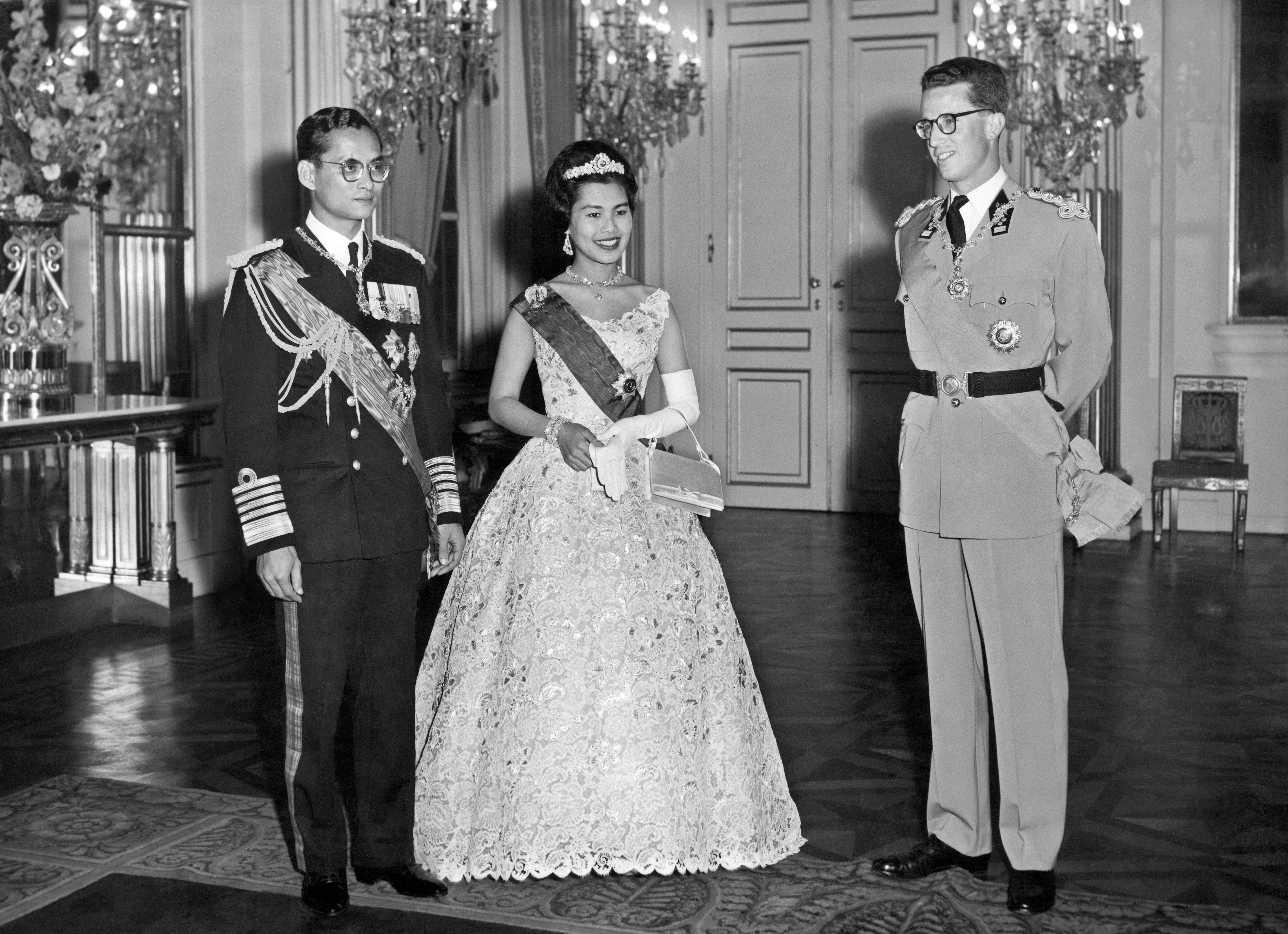 Thai King Bhumibol Adulyadej (L) and Queen Sirikit (C) stand near Belgium King Baudouin I, on October 1960 in Brussels, during their offcil visit to Belgium. / AFP PHOTO / BELGA