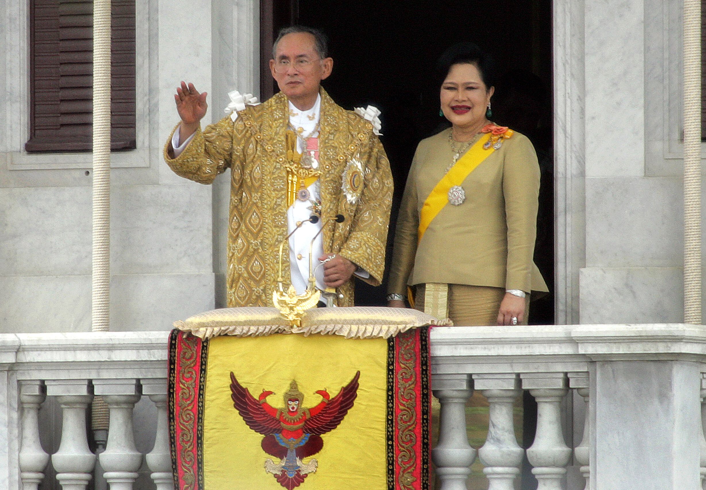 Thai King Bhumibol Adulyadej along with Queen Sirikit wave to thier people after his address in Bangkok, 09 June 2006. Nearly one million Thais wearing yellow shirts flocked into central Bangkok for the king's first public audience in six years, marking his 60th anniversary on the throne, police said. The king called for unity among his people after months of political turmoil, in a speech to mark his 60th anniversary on the throne. AFP PHOTO/PORNCHAI KITTIWONGSAKUL / AFP PHOTO / PORNCHAI KITTIWONGSAKUL