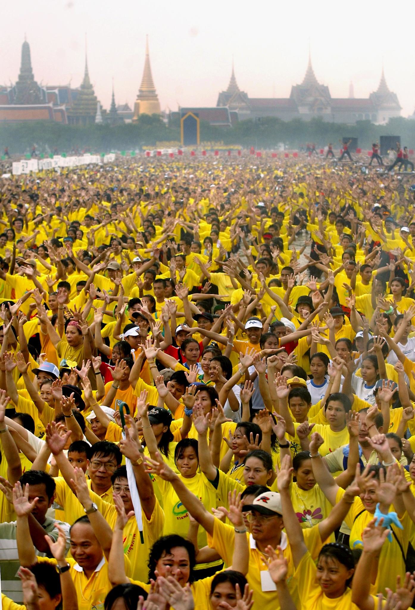 A massive crowd participates in an aerobics session near the Royal Palace 23 November 2002 as part of a global movement for health aimed at being the world's largest health festival and led by Thailand's Prime Minister Thaksin Shinawatra. The massive outdoor aerobics exercise session led by Thaksin and involving more than 50,000 people aims to break the world record. The event joins yearlong national efforts around the world to take further this year's World Health Day theme, "Move for Health". AFP PHOTO/Stephen SHAVER / AFP PHOTO / STEPHEN SHAVER