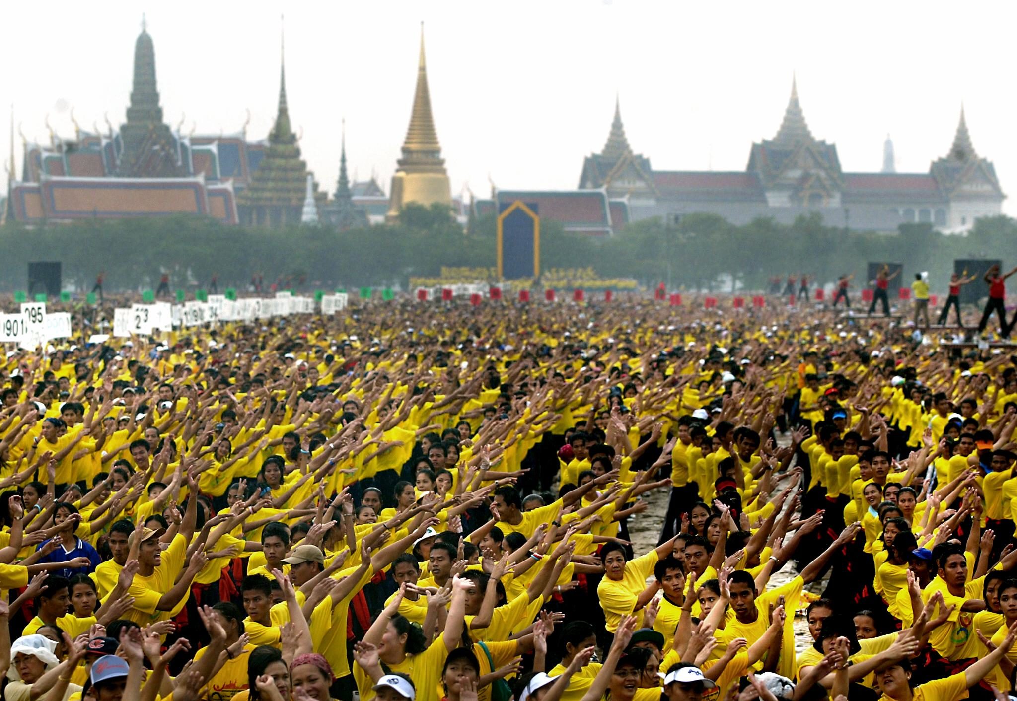 A massive crowd participates in an aerobics session near the Royal Palace in Bangkok, 23 November 2002, as part of a global movement for health aimed at being the world's largest health festival and led by Thailand's Prime Minister Thaksin Shinawatra. The massive outdoor aerobics exercise session led by Thaksin and involving more than 50,000 people aims to break the world record. The event joins yearlong national efforts around the world to take further this year's World Health Day theme, "Move for Health". AFP PHOTO/Stephen SHAVER / AFP PHOTO / STEPHEN SHAVER