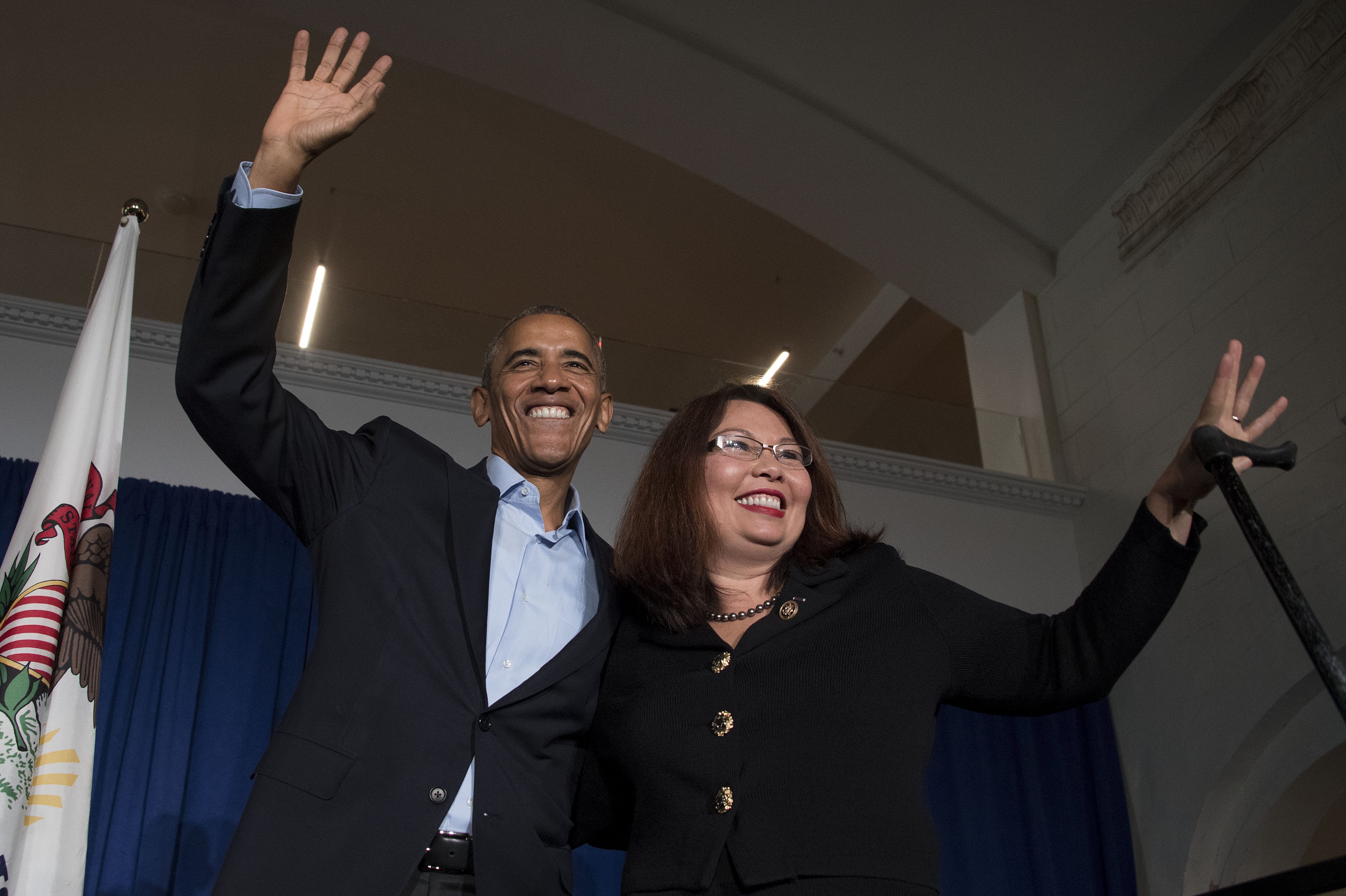 US President Barack Obama waves to the crowd with Congresswoman Tammy Duckworth, D-IL, (R) during a Coordinated Victory Fund Event in Chicago, Illinois, October 9, 2016. / AFP PHOTO / JIM WATSON