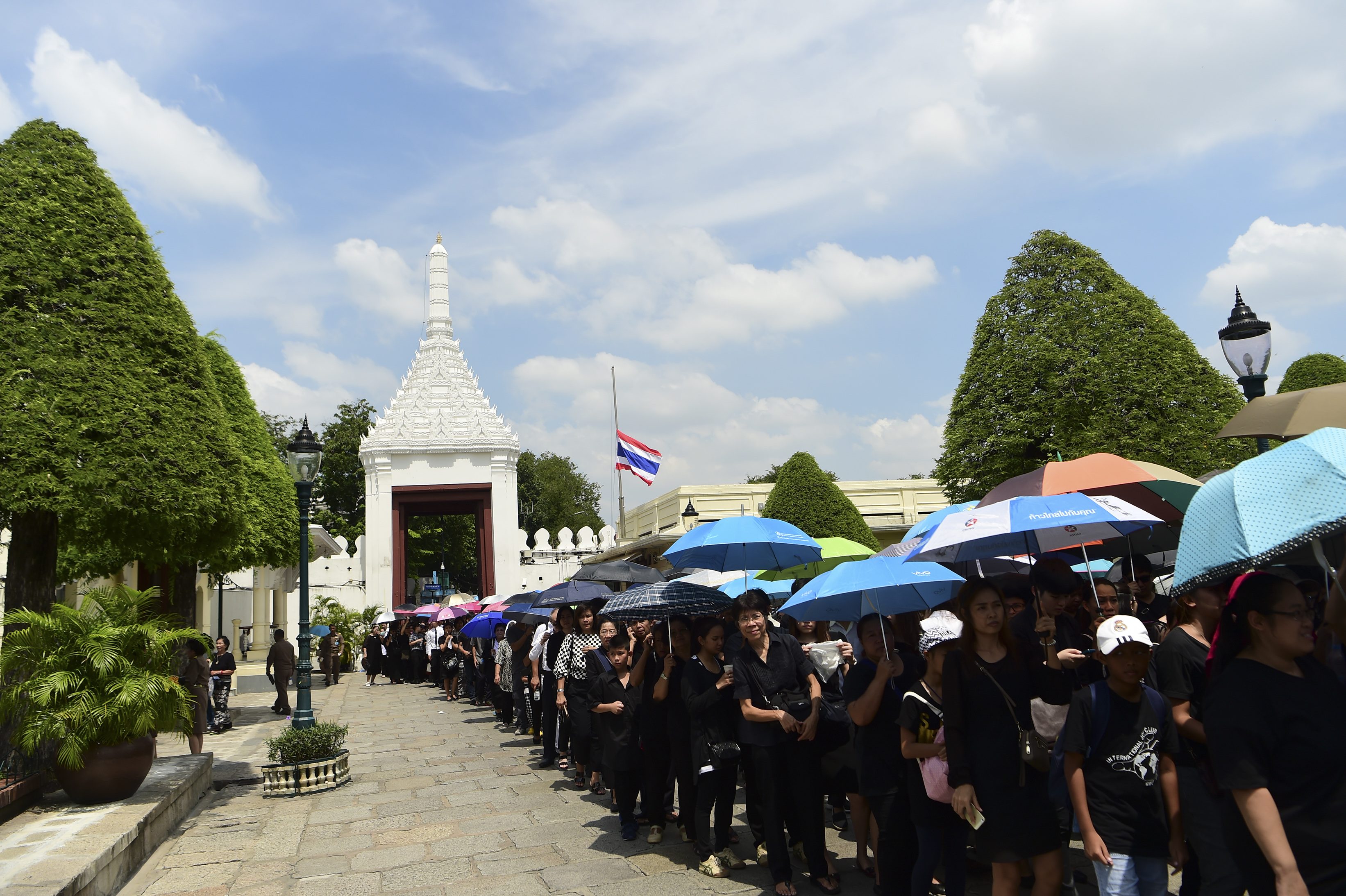 People line up to pay their respects to the late Thai King Bhumibol Adulyadej at the Grand Palace in Bangkok on October 14, 2016. Bhumibol, the world's longest-reigning monarch, passed away aged 88 on October 13, 2016 after years of ill health, removing a stabilising father figure from a country where political tensions remain two years after a military coup. / AFP PHOTO / MUNIR UZ ZAMAN