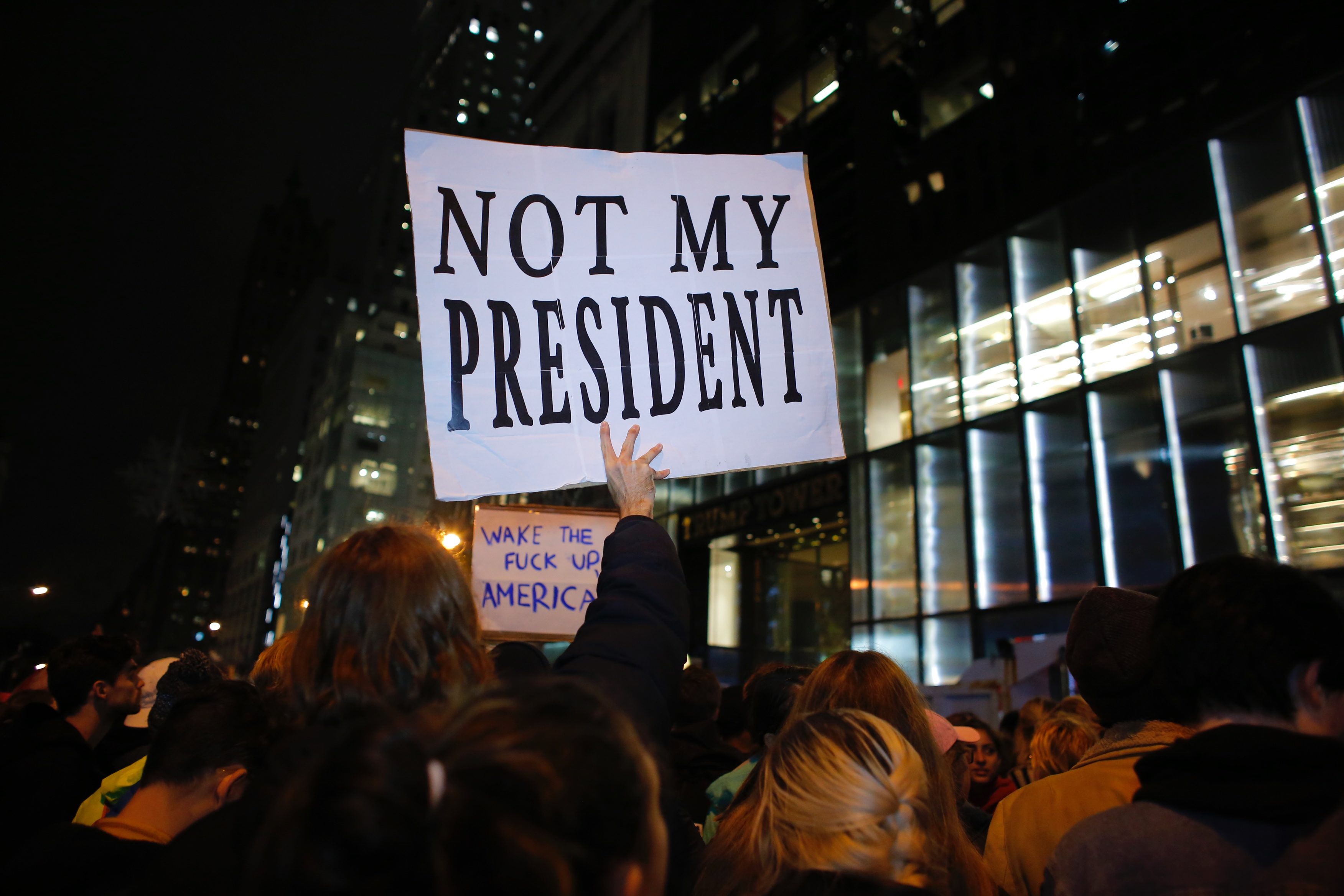 A man holds a Poster as he takes part during a protest againts elected president Donald Trump on November 9, 2016 in New York City.