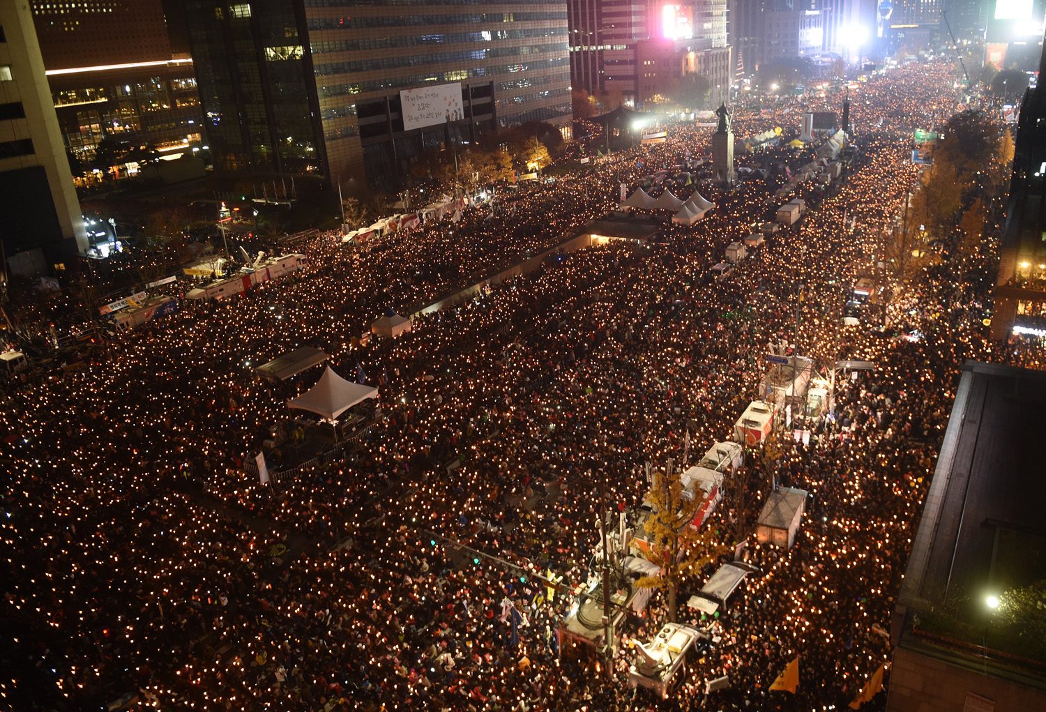 Tens of thousands of protesters hold candles during an anti-government rally in central Seoul on November 19, 2016 aimed at forcing South Korean President Park Geun-Hye to resign over a corruption scandal. Tens of thousands of protestors gathered in Seoul for the fourth in a weekly series of mass protests aimed at forcing President Park Geun-Hye to resign over a corruption scandal. / AFP PHOTO / POOL / JUNG YEON-JE