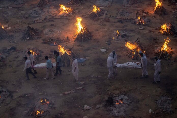 People bring the bodies of COVID-19 victims for cremation at a crematorium ground in New Delhi